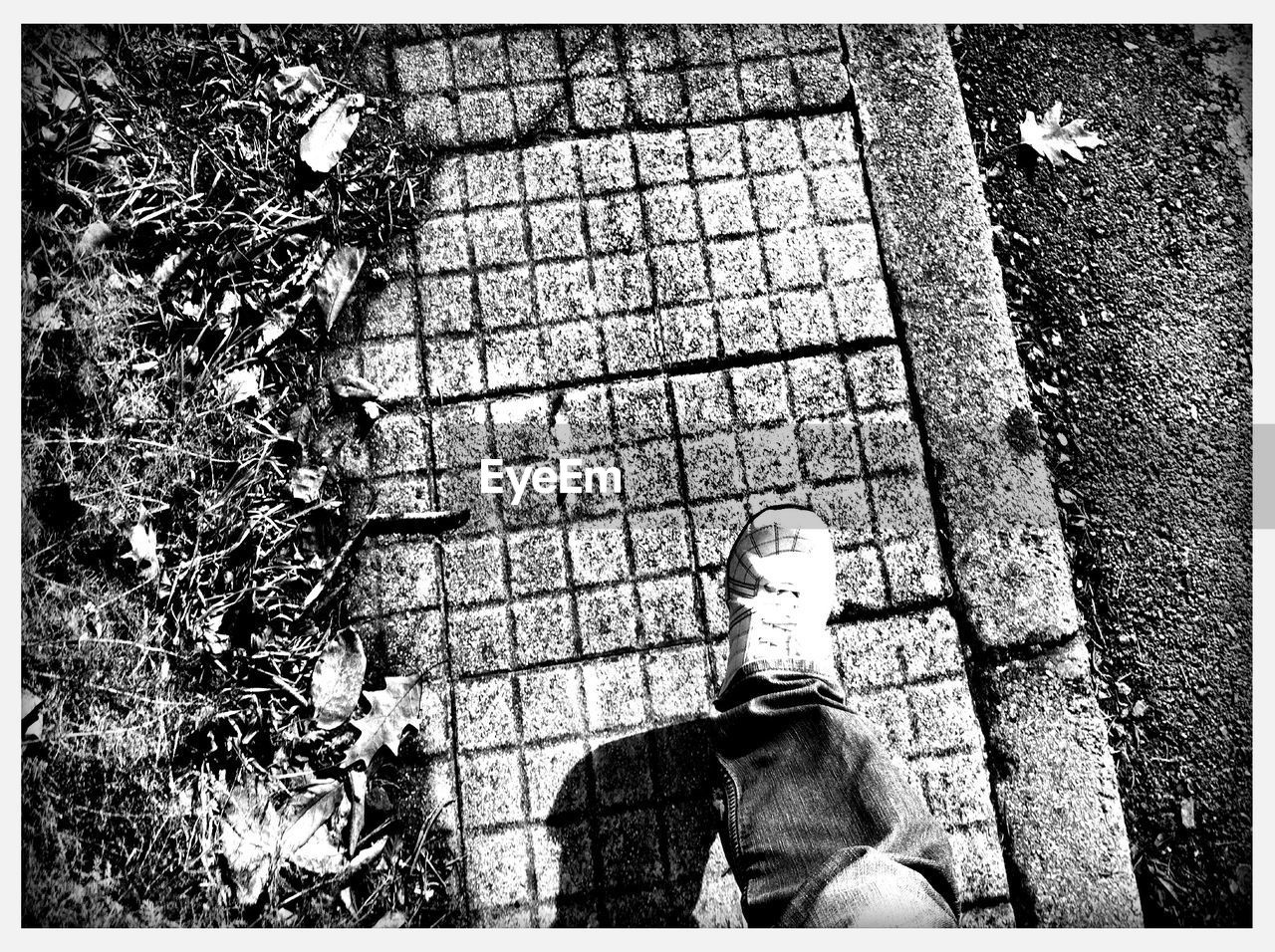 HIGH ANGLE VIEW OF MAN STANDING ON FOOTPATH