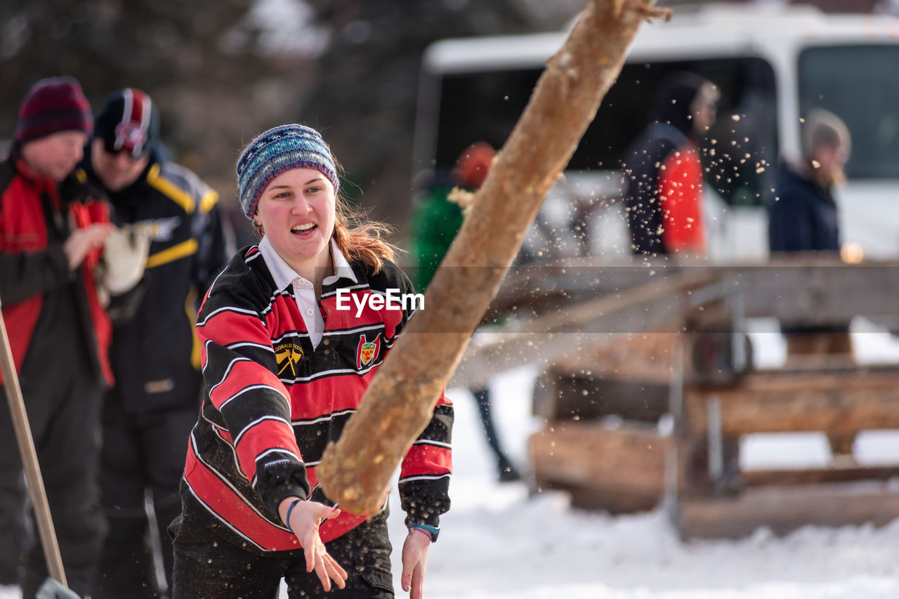 FULL LENGTH OF HAPPY WOMAN HOLDING SNOW