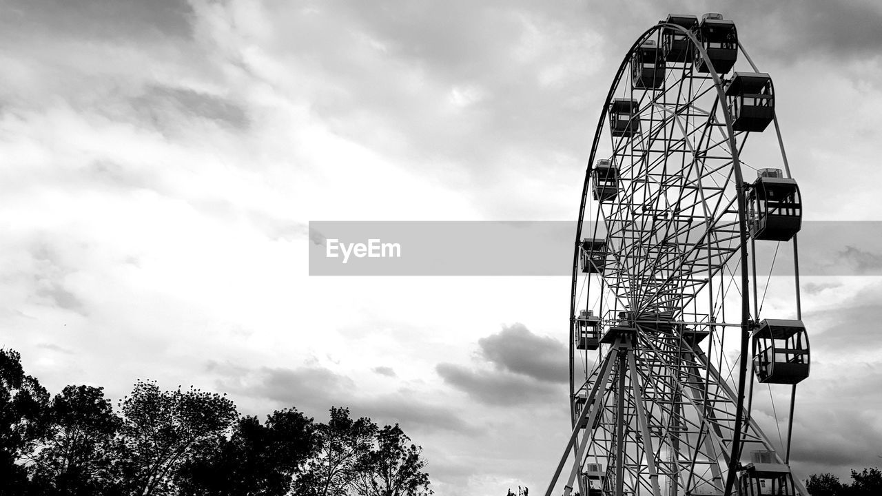 LOW ANGLE VIEW OF FERRIS WHEEL AGAINST CLOUDY SKY