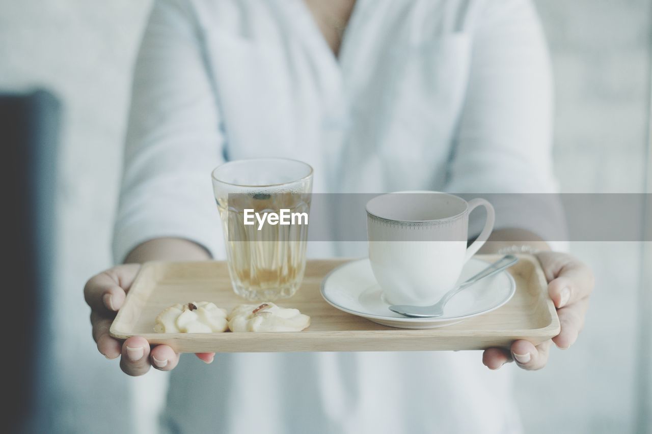 Midsection of woman holding drinks in tray