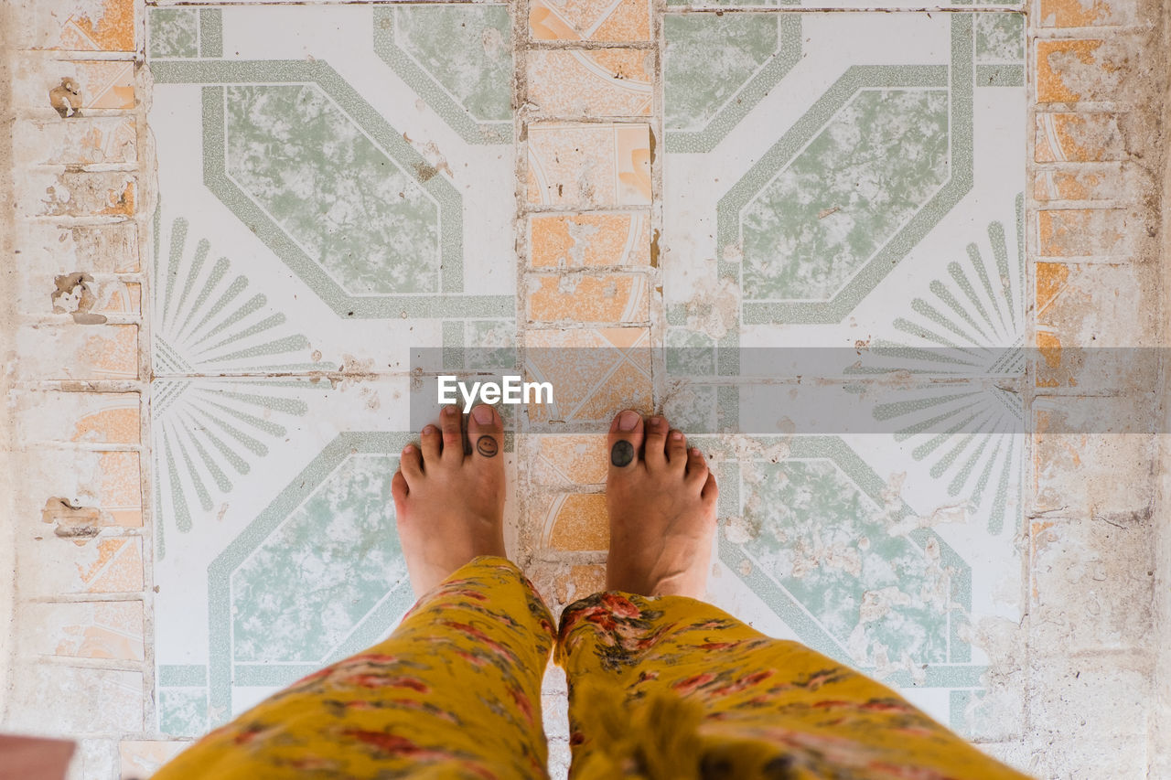 Low section of woman standing on tiled floor