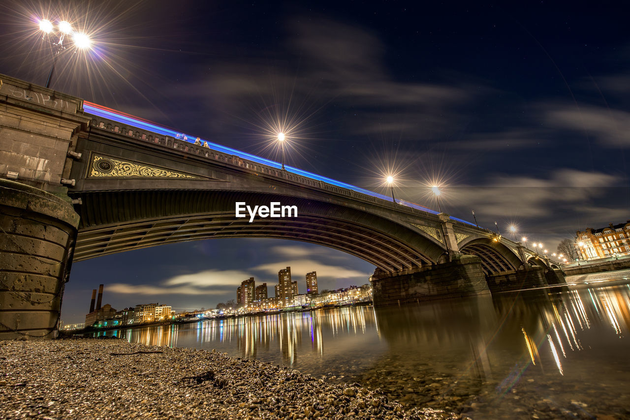 Low angle view of illuminated battersea bridge against sky at night