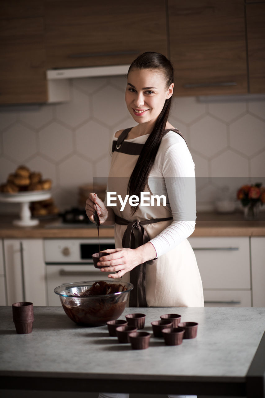 Portrait of chef preparing batter in kitchen