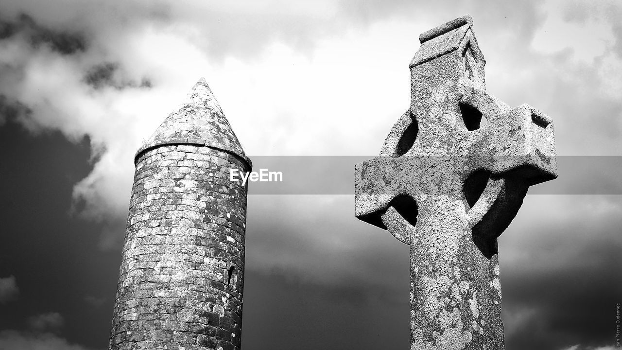 Low angle view of celtic cross and tower