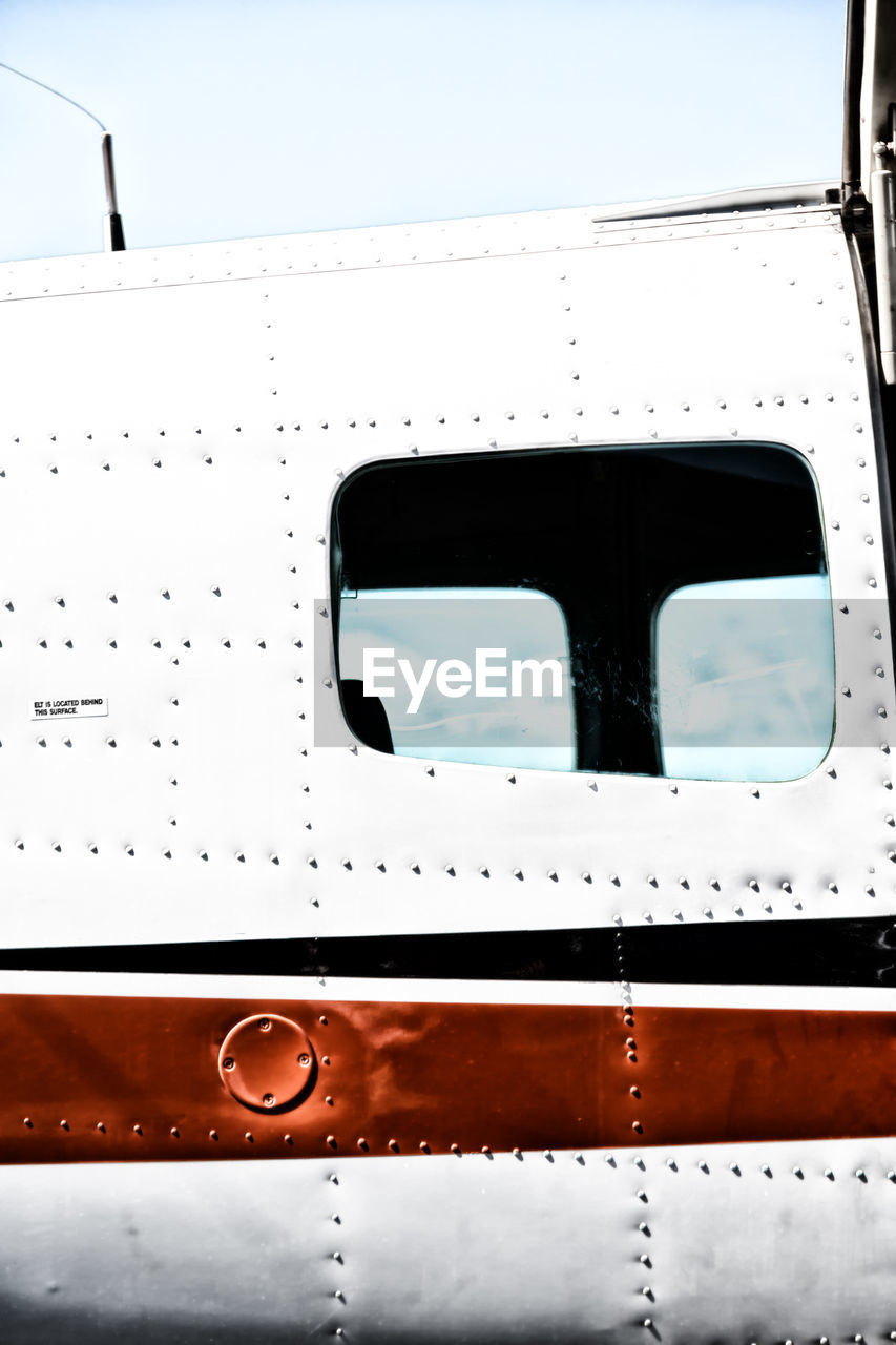 CLOSE-UP OF AIRPLANE WINDOW IN SKY