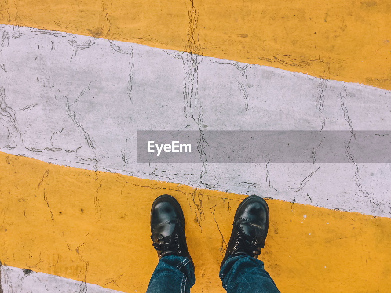 Low section of man standing on zebra crossing