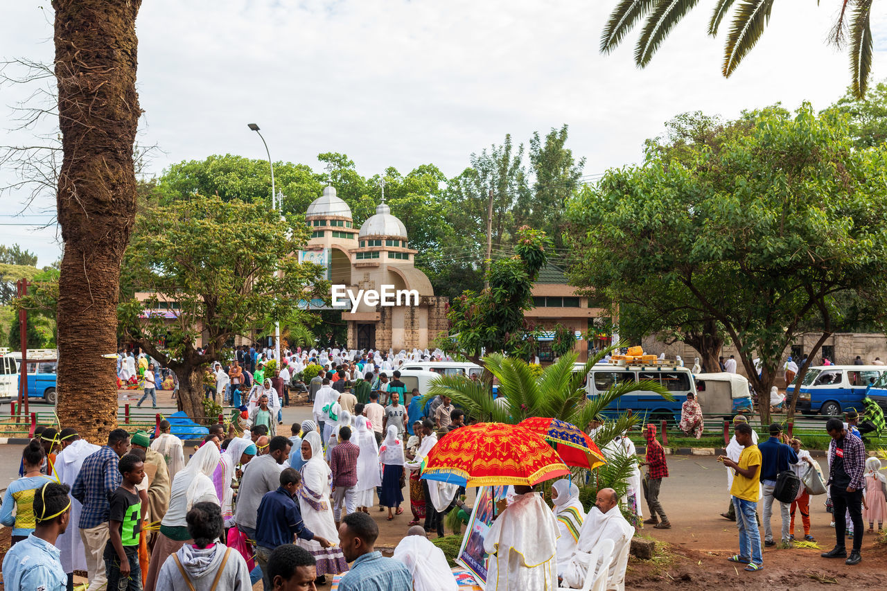 GROUP OF PEOPLE IN TEMPLE AGAINST SKY