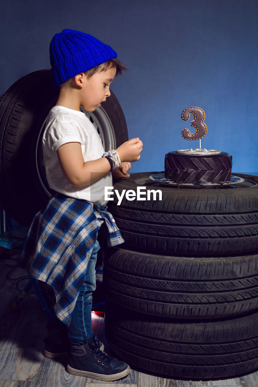 Baby boy eats his birthday cake in the form of a wheel in the studio