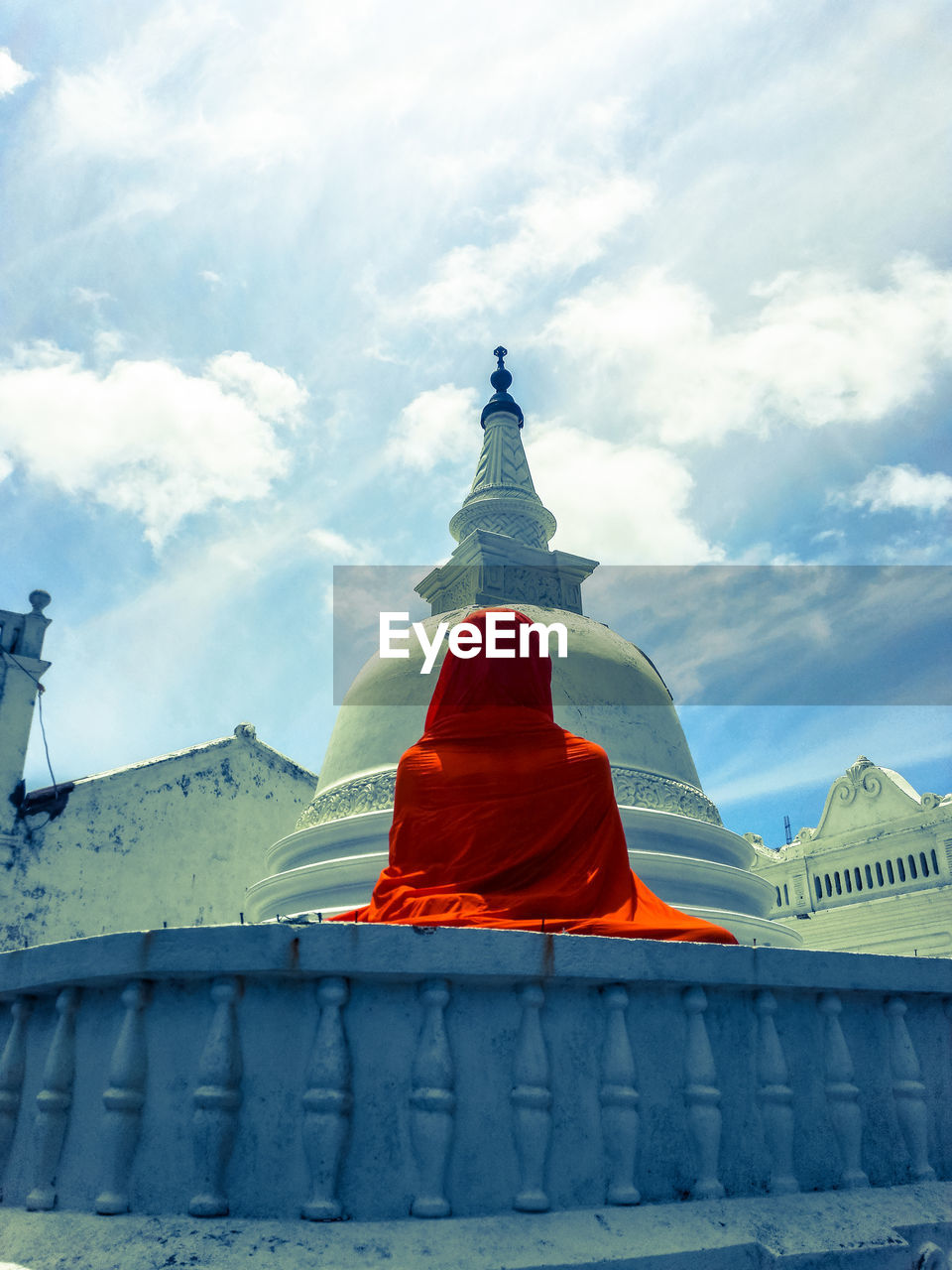 Low angle view of statue covered with fabric at temple against sky