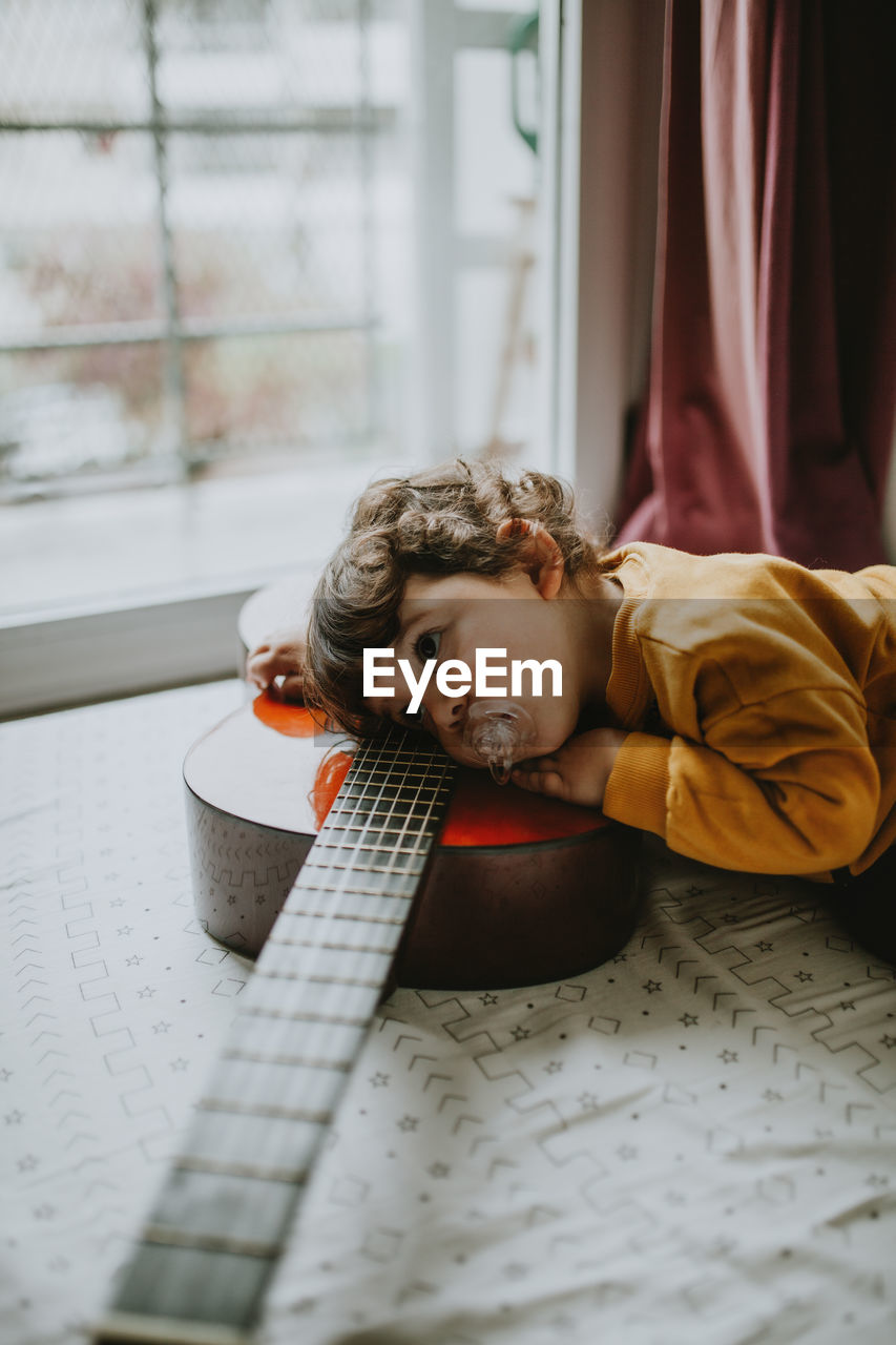 Portrait of child playing guitar at home