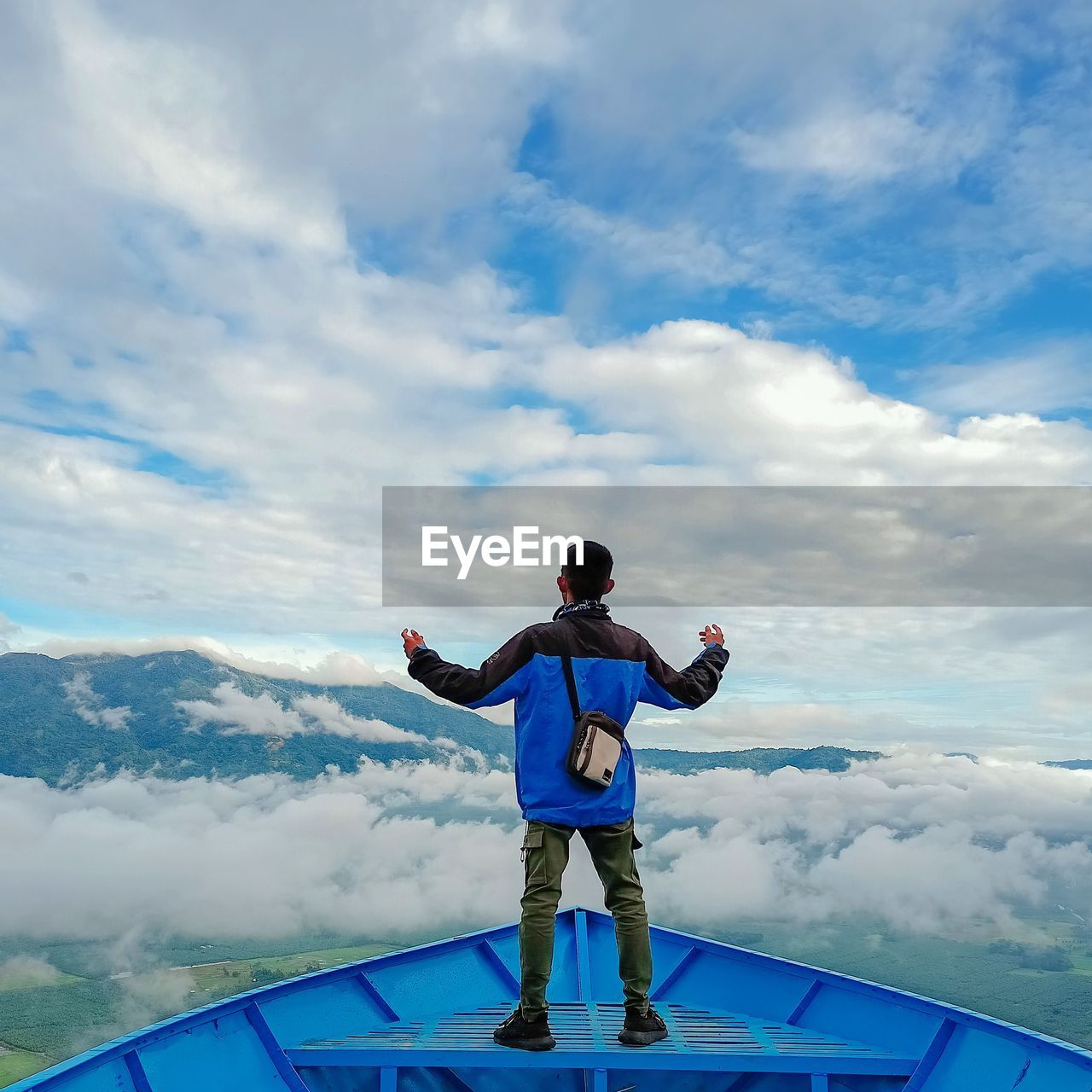 Rear view of boy standing against sky