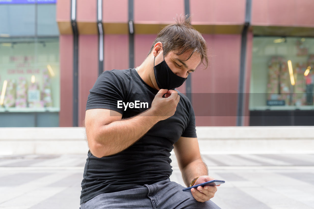 YOUNG MAN USING MOBILE PHONE