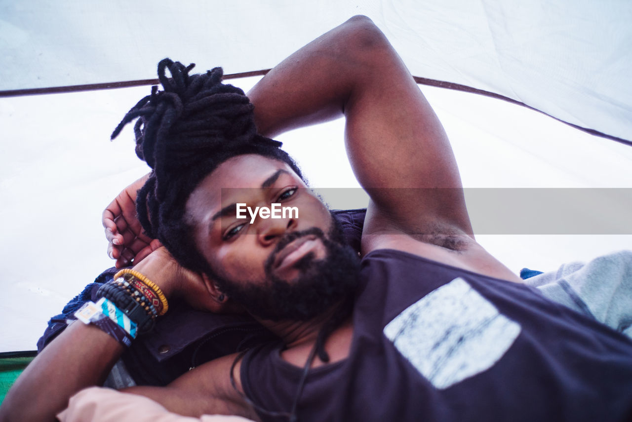 PORTRAIT OF YOUNG MAN LYING DOWN