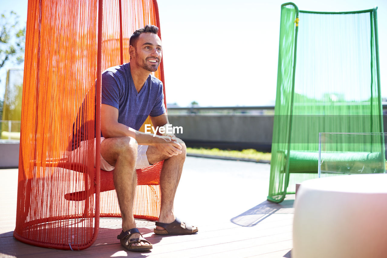 A man sitting in a colorful modern chair.