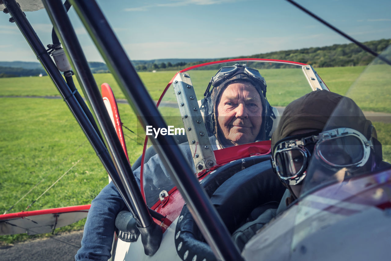 Germany, dierdorf, grandfather and grandson sitting on old biplane