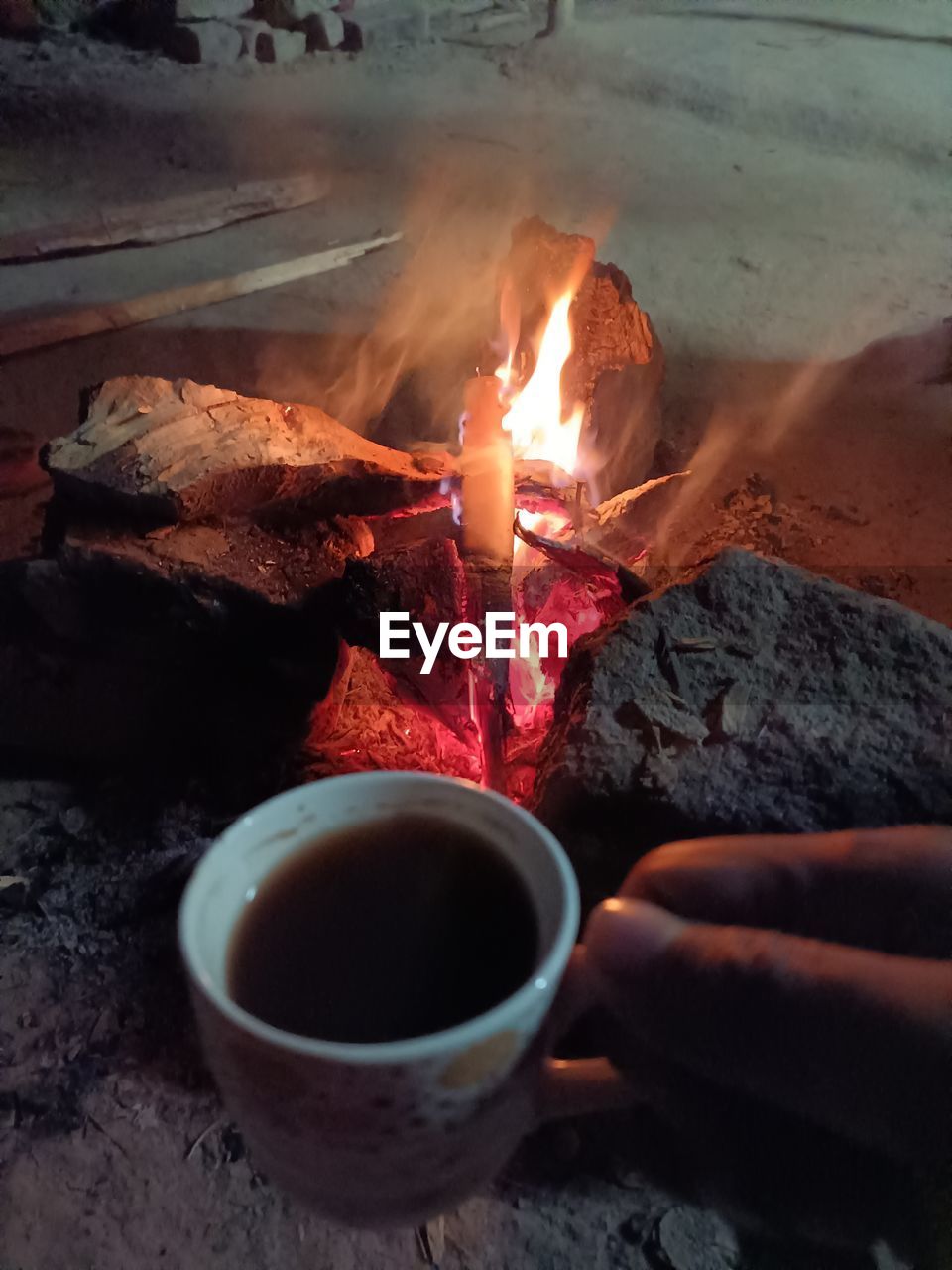 Cropped hand of person burning tea