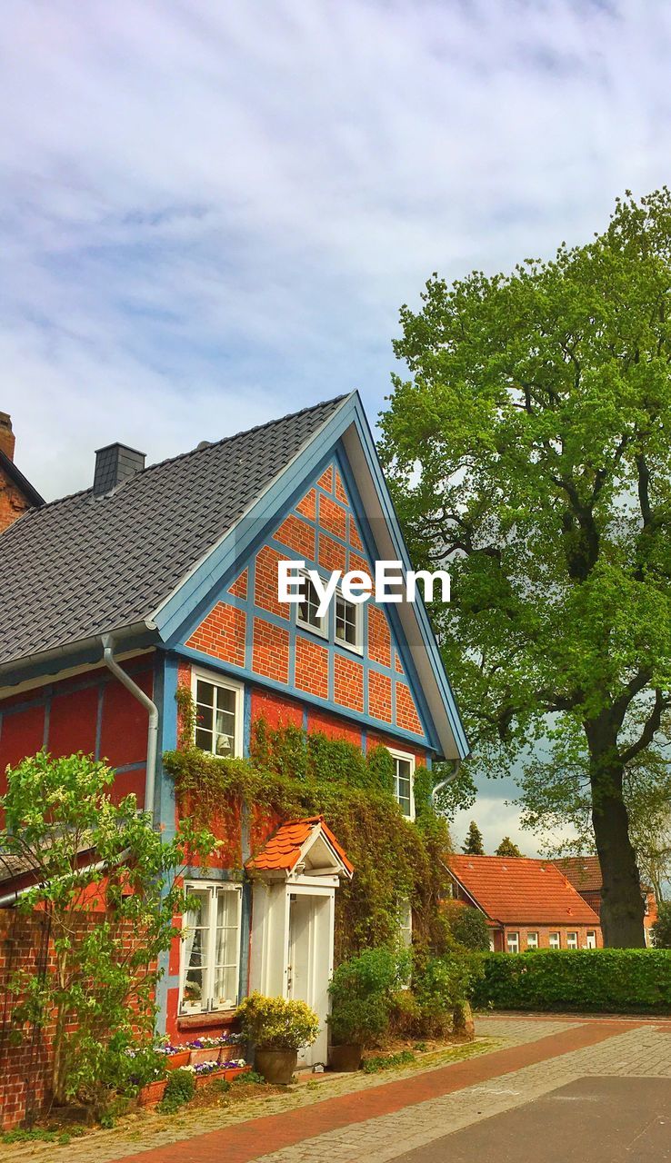 HOUSE BY TREES AGAINST SKY