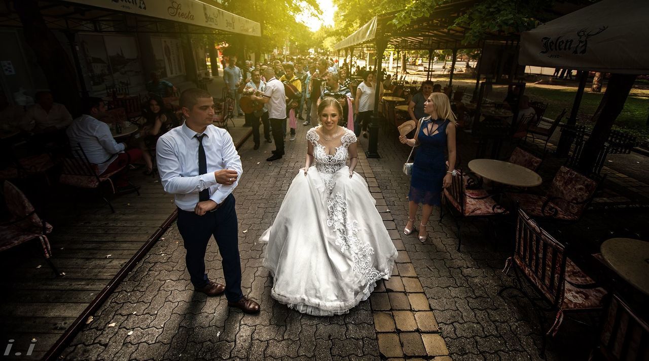 REAR VIEW OF PEOPLE WALKING ON STREET