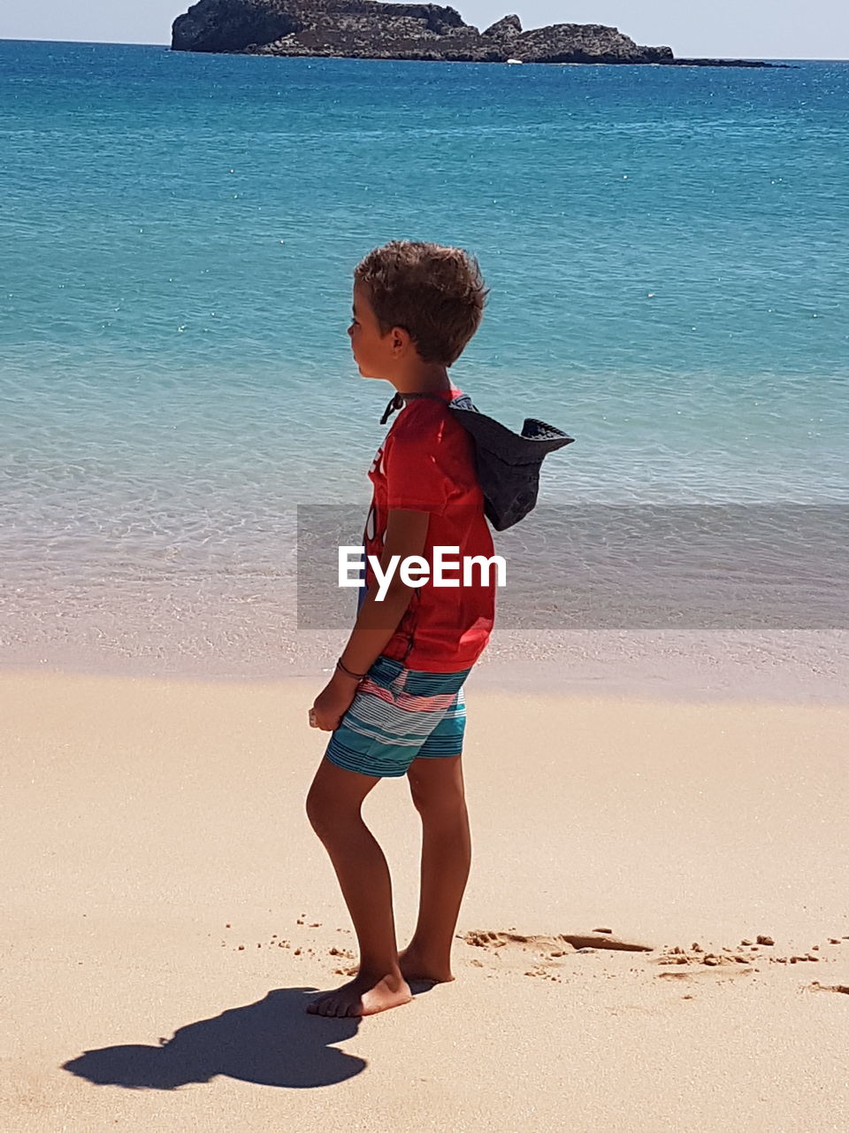 Full length of boy standing on shore at beach