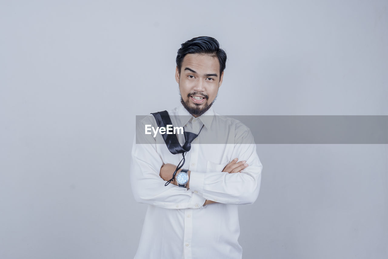 PORTRAIT OF MAN WEARING MASK AGAINST WHITE BACKGROUND