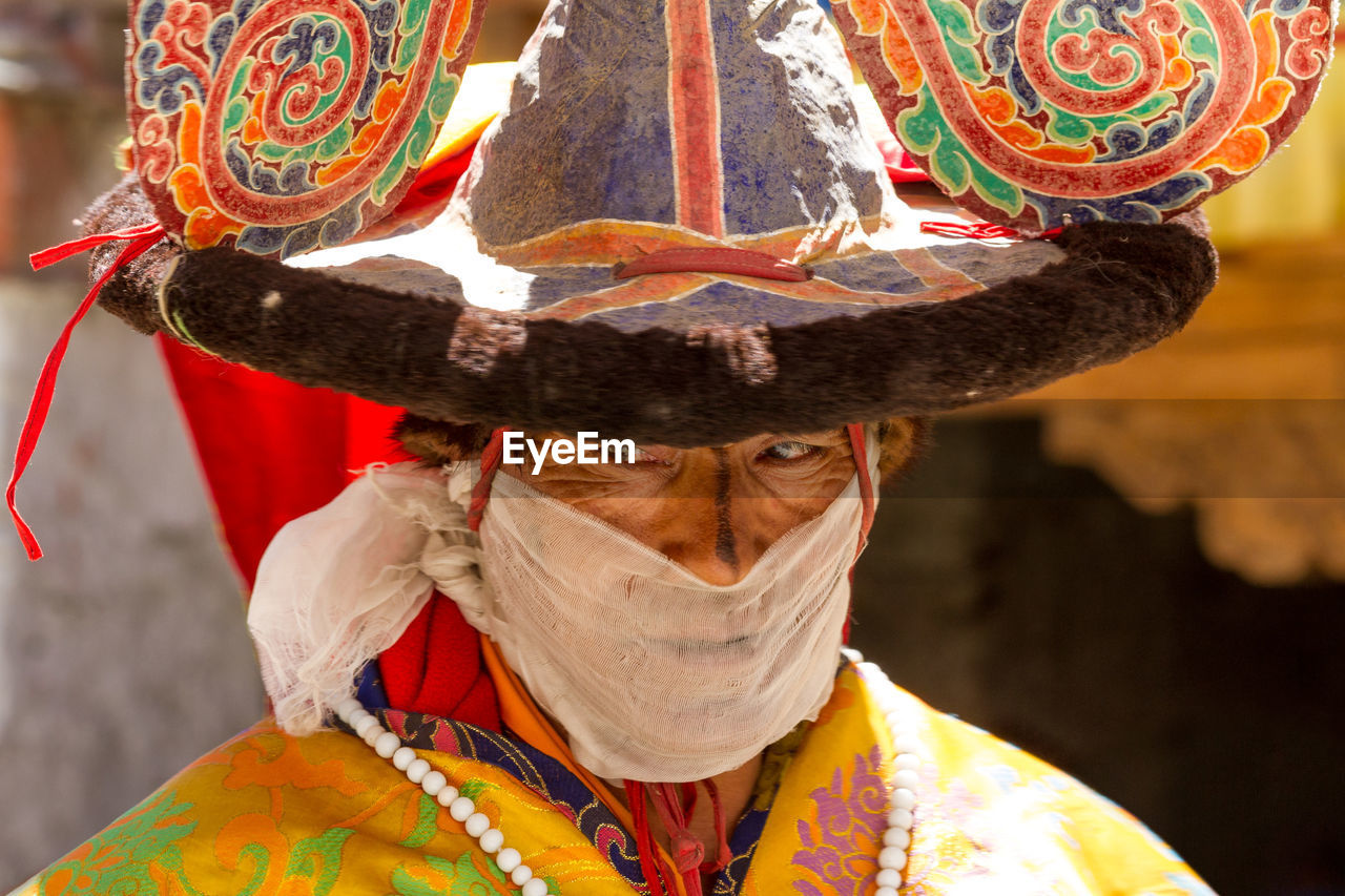 PORTRAIT OF PERSON WITH HAT WEARING MASK