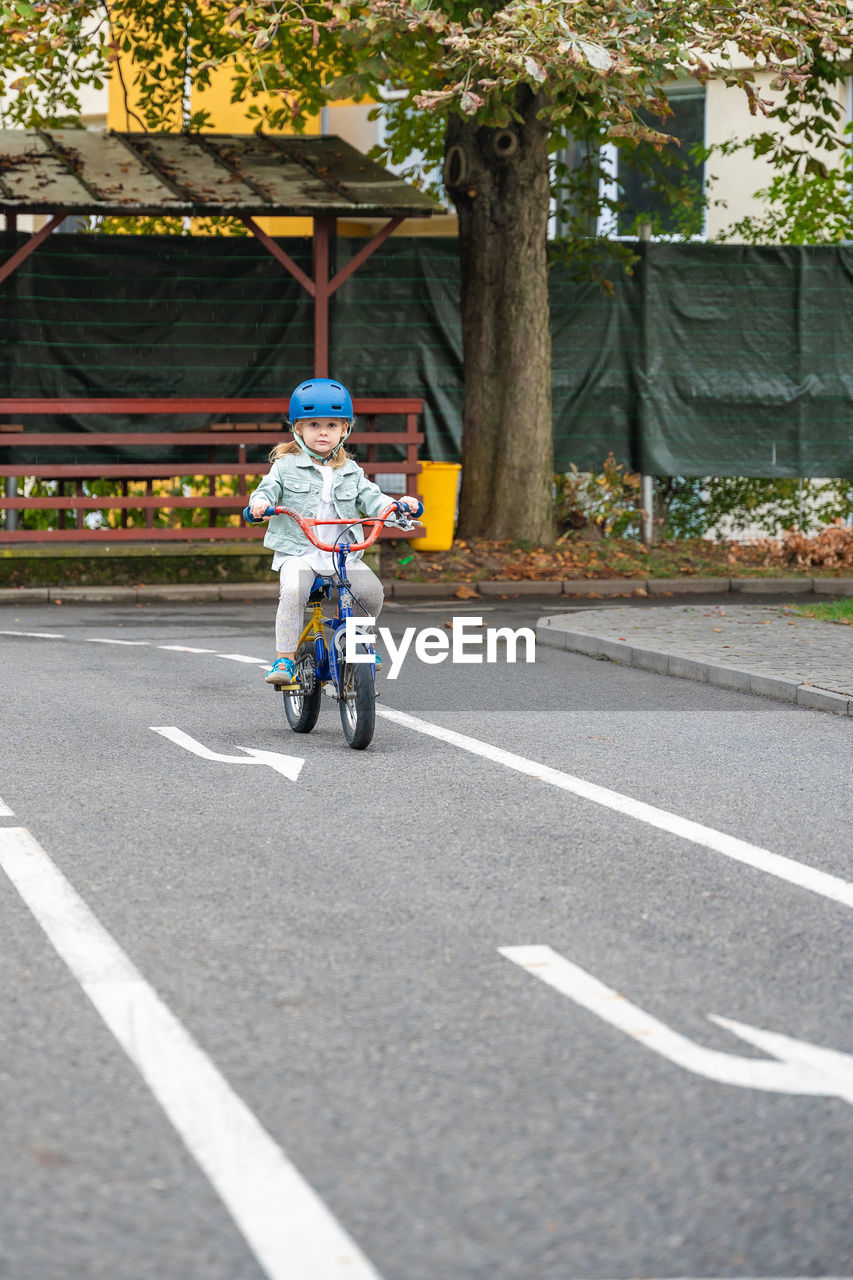 side view of man riding push scooter on road