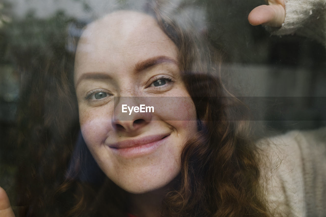 Smiling woman seen through glass