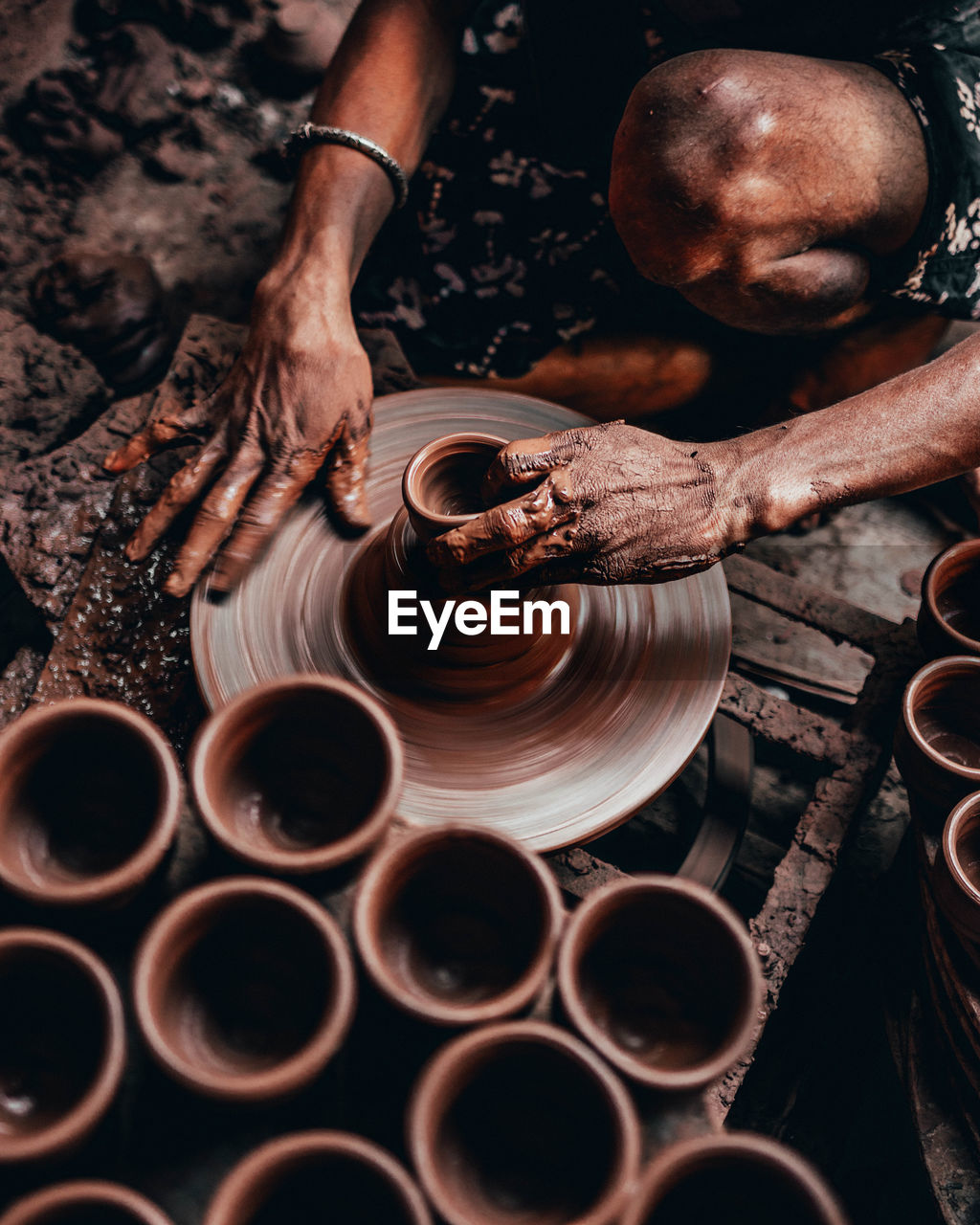 Midsection of person working on pottery wheel