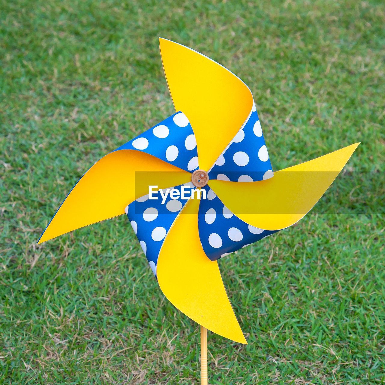 CLOSE-UP OF YELLOW TOY ON FIELD
