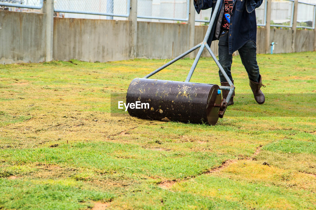 LOW SECTION OF MAN WORKING ON GRASS