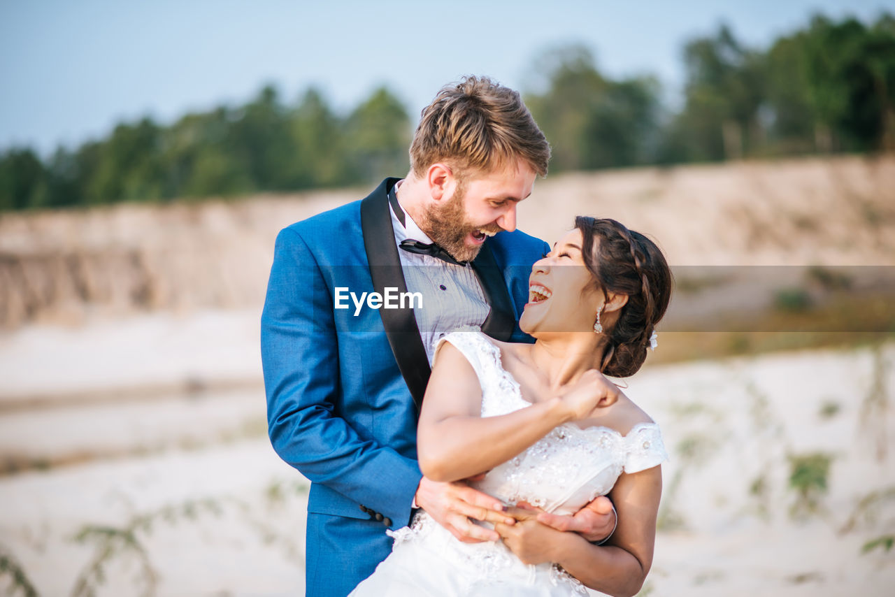 Happy couple embracing while standing outdoors