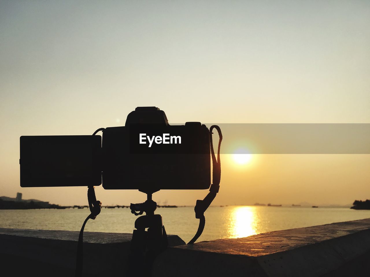 CLOSE-UP OF SILHOUETTE CAMERA AGAINST SKY DURING SUNSET