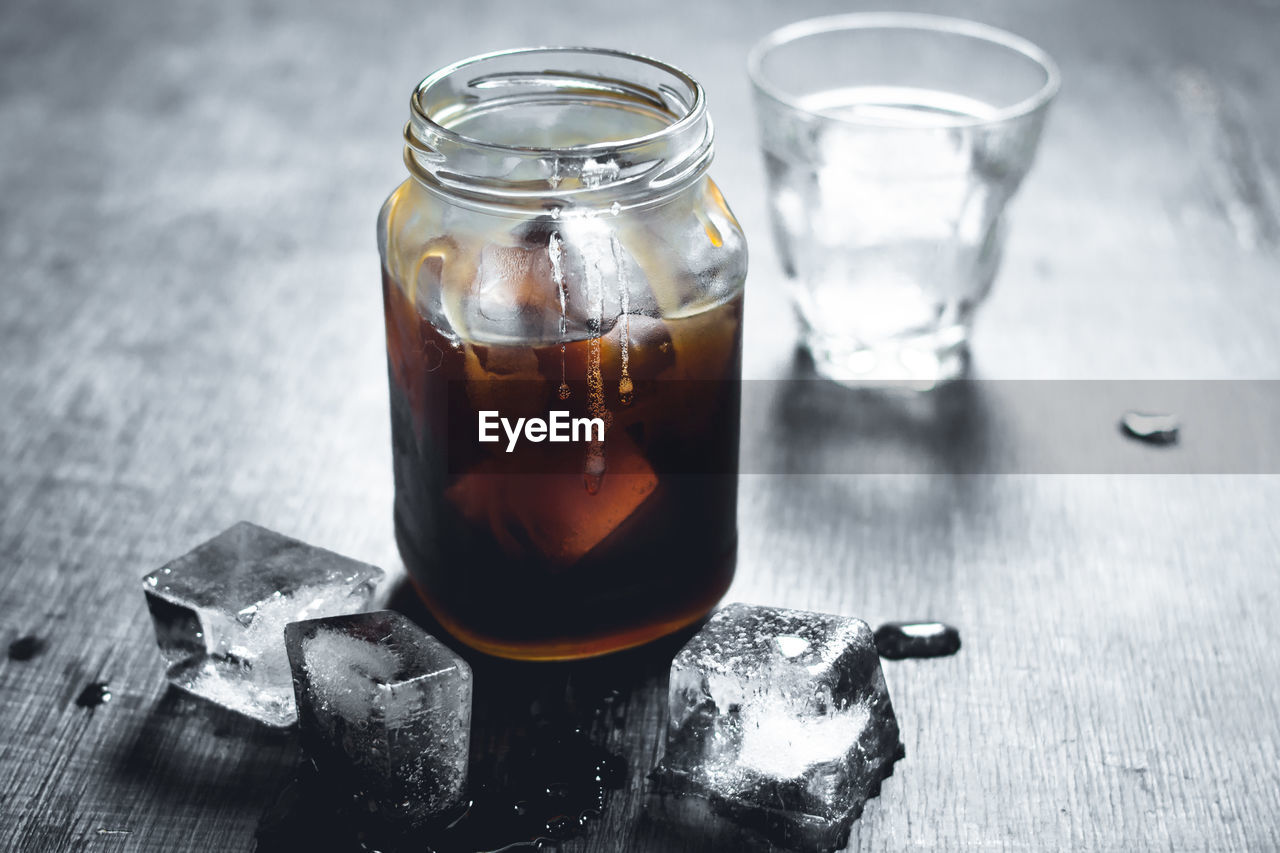 Close-up of drink in glass jar with ice on table