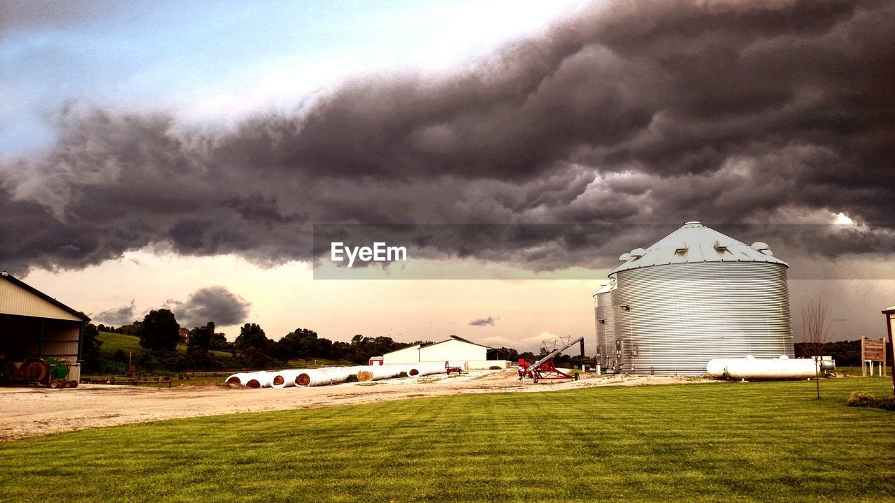 Storm clouds over silos on agricultural land