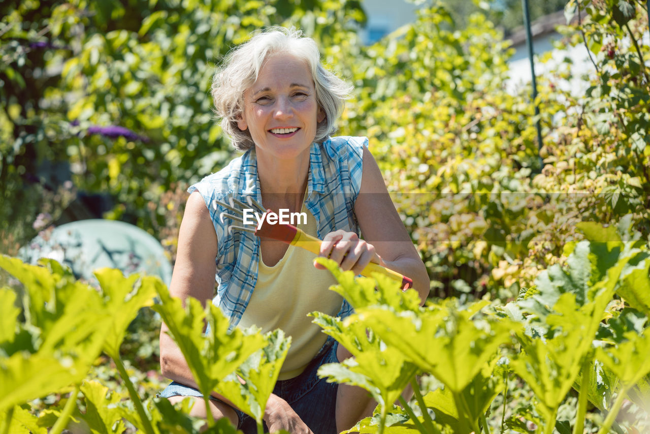 Portrait of smiling woman amidst plants
