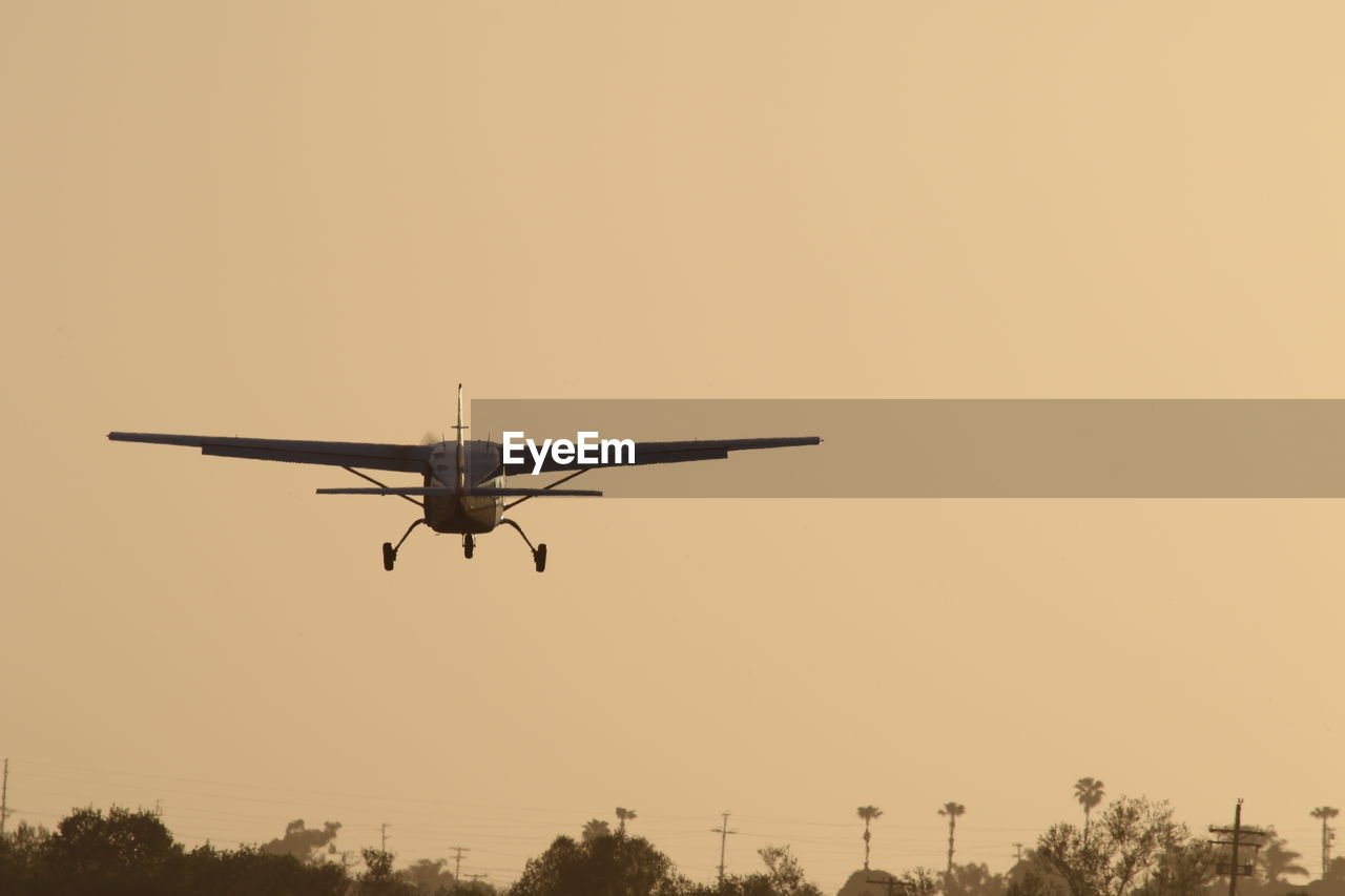 Low angle view of airplane against clear sky during sunset 