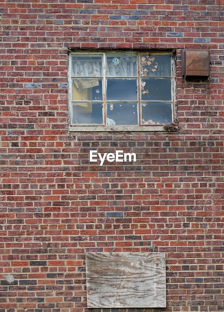 Old dirty window on brick wall 