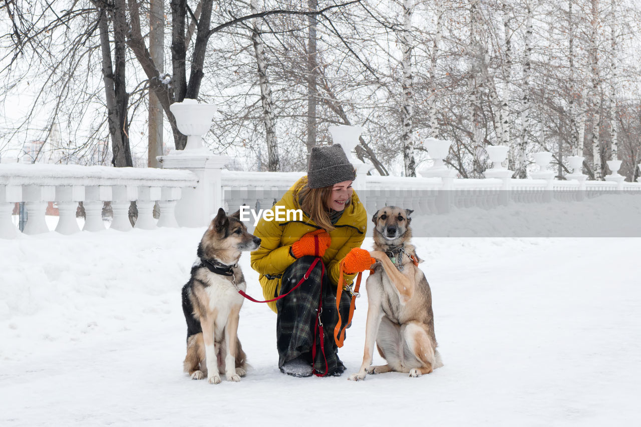 Woman with dogs on snow covered street