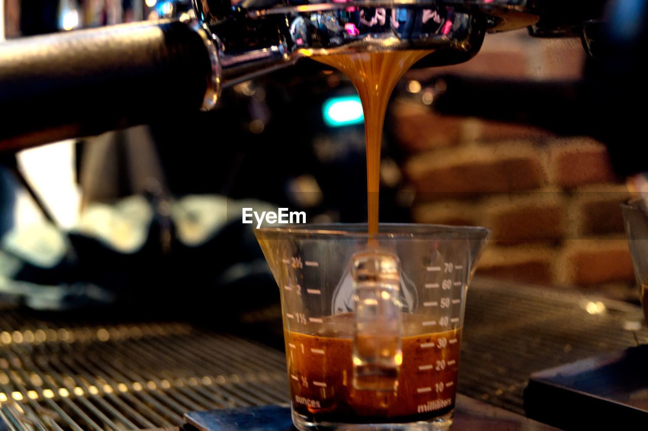 Close-up of coffee pouring in jar on table