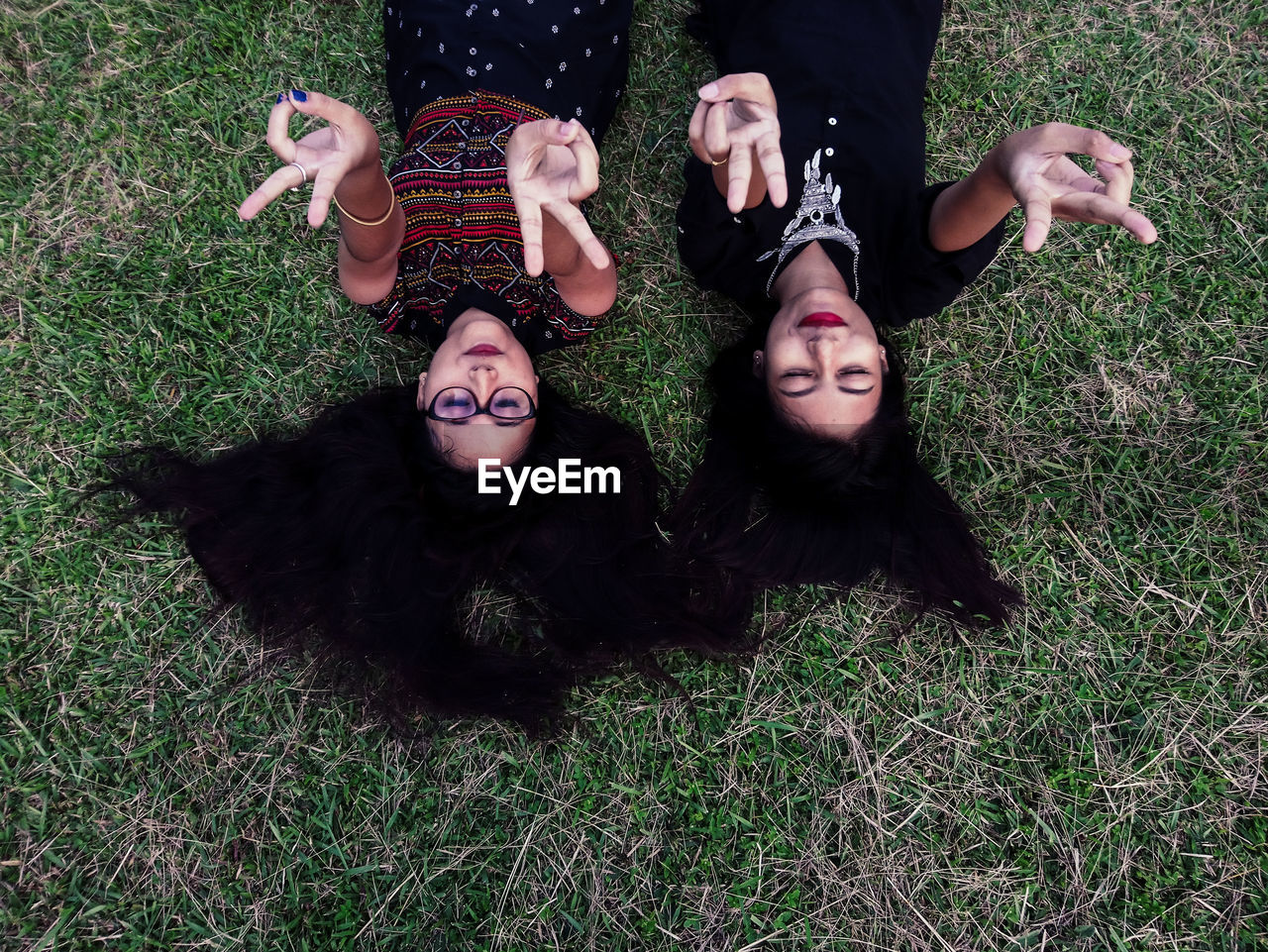 High angle view of female friends lying on grass