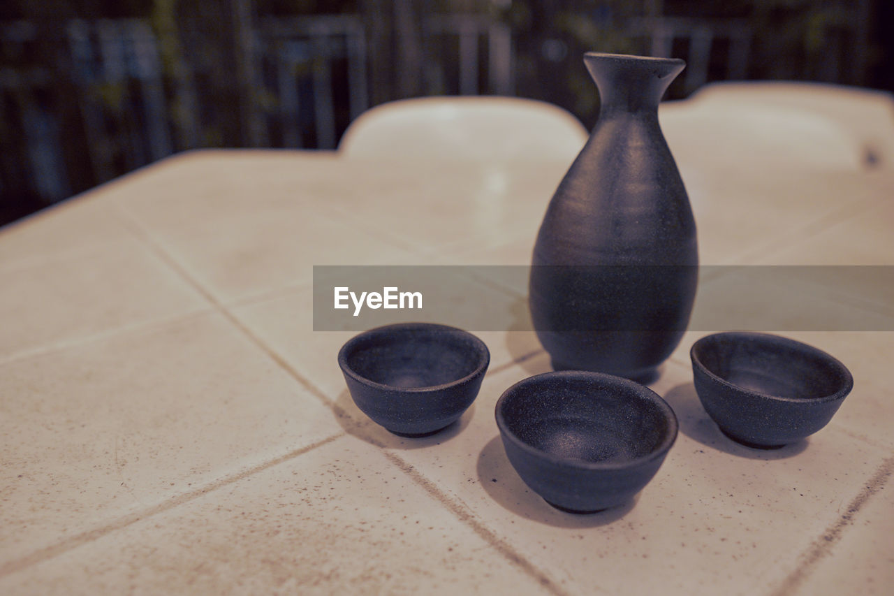 Close-up of pottery and cups on table