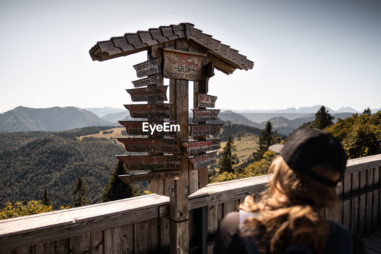 REAR VIEW OF WOMAN LOOKING AT VIEW OF MOUNTAIN RANGE