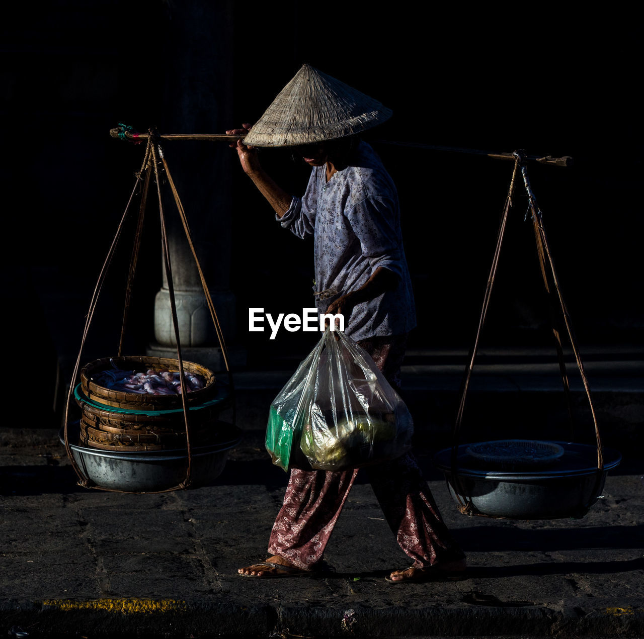 Vietnamese vendor walking at market