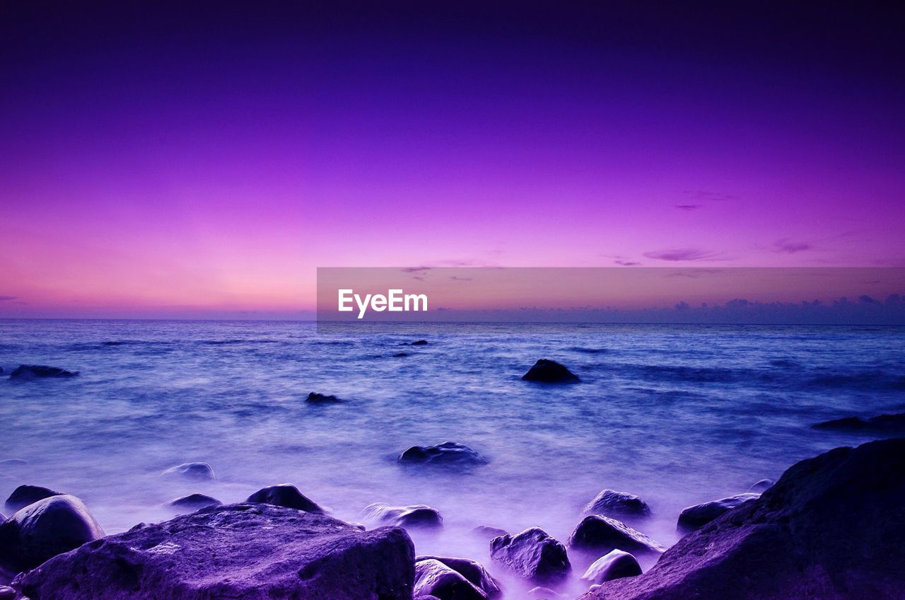 SCENIC VIEW OF BEACH AGAINST SKY DURING SUNSET