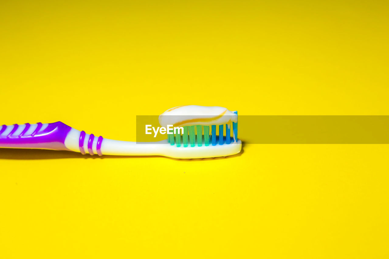 CLOSE-UP OF YELLOW PLASTIC OVER COLORED BACKGROUND