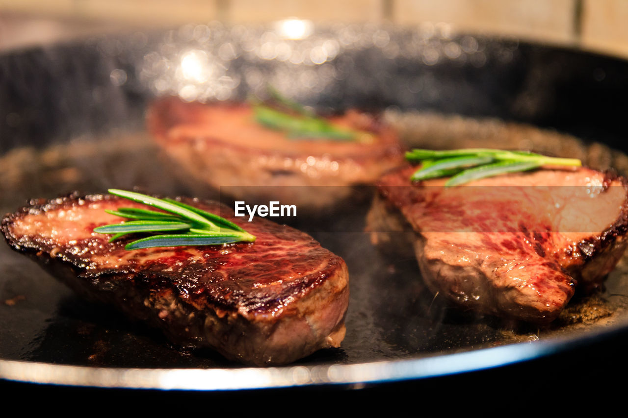 CLOSE-UP OF MEAT IN COOKING PAN