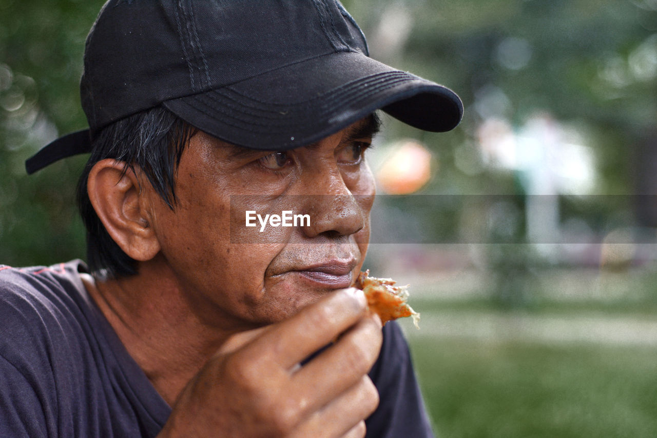 Close-up of thoughtful mature man eating food