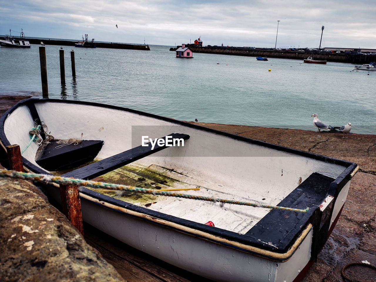 BOAT MOORED ON SEA AGAINST SKY