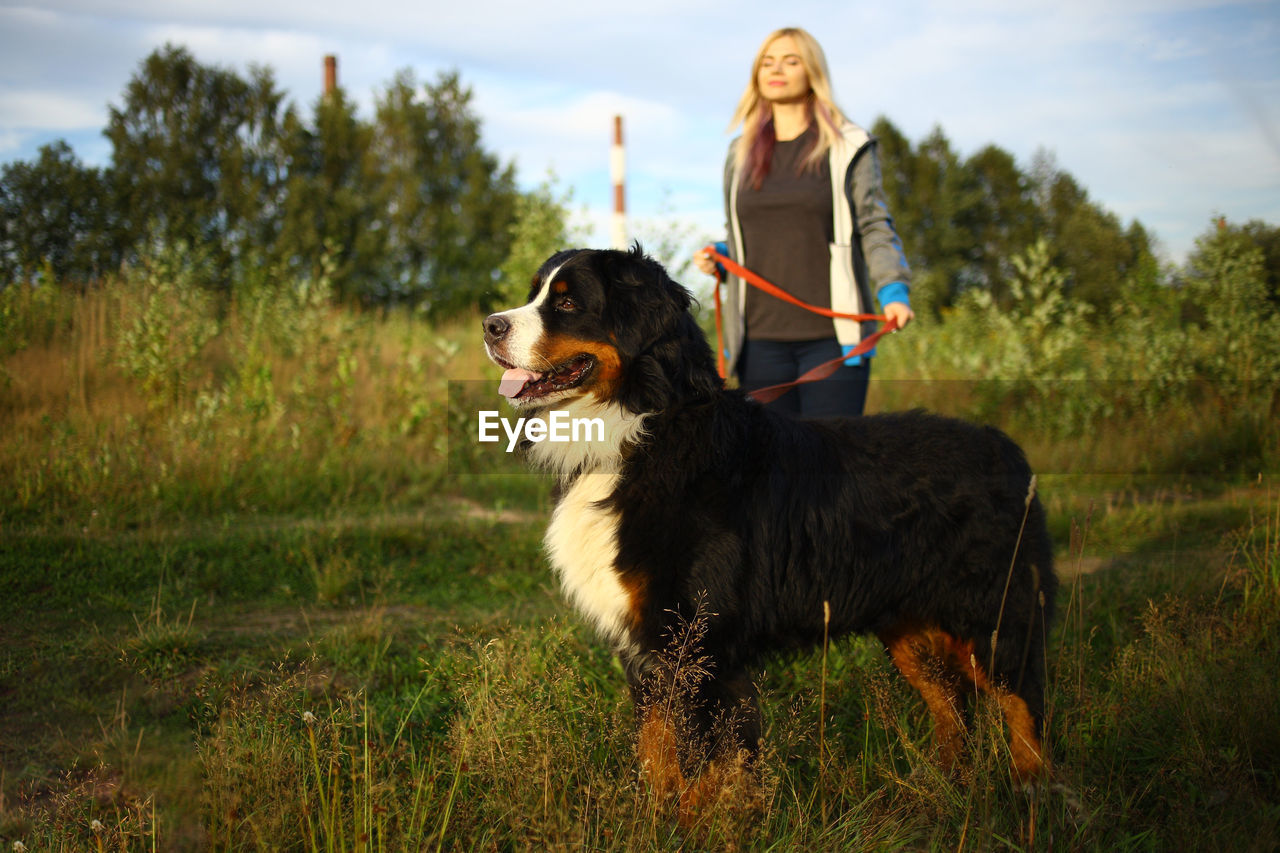 Woman standing with dog outdoors
