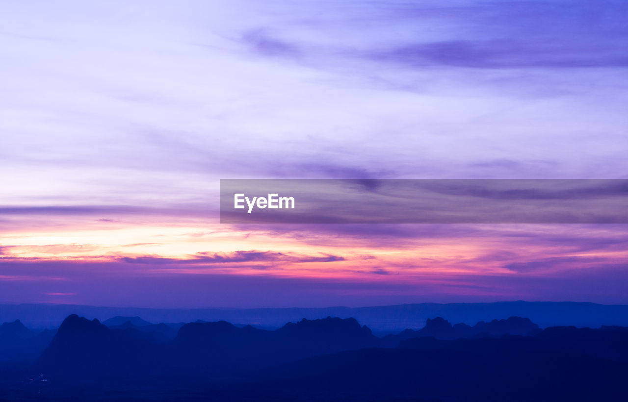 SCENIC VIEW OF DRAMATIC SKY OVER SILHOUETTE MOUNTAINS